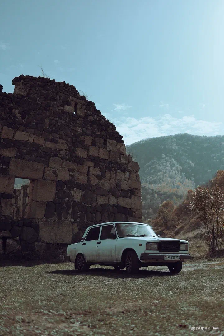 Una Lada 2107 bianca parcheggiata davanti alle rovine di Hnevank