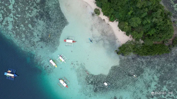 Bangke ancorate sul reef accanto a un banco di sabbia bianca a Coron, viste dal drone