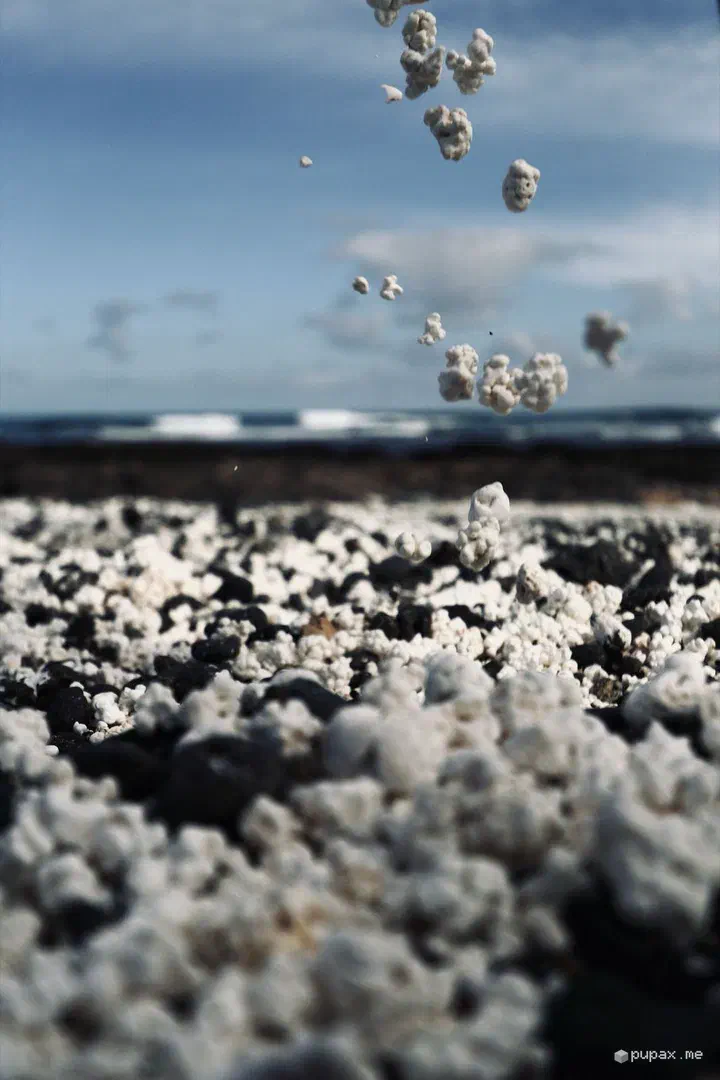 Una manciata di sassolini bianchi lanciati in aria a Pop Corn Beach