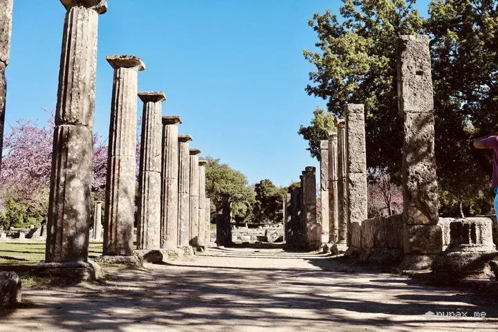 Il colonnato della palestra di Olimpia tra gli alberi in fiore