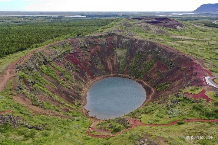 Il cratere di Kerið visto dal drone: pareti di terra rossa e un lago azzurro sul fondo