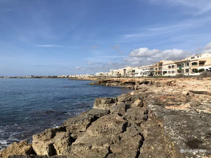 Scogli piatti e case bianche affacciate sul mare a Sa Ràpita
